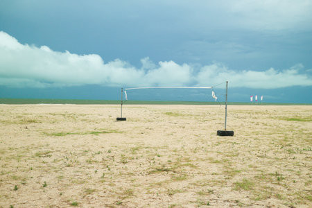 Empty beach volleyball court with clear blue sky and calm sea. Scenic tropical beach atmosphere in Southeast Asia, perfect for summer concepts.の写真素材