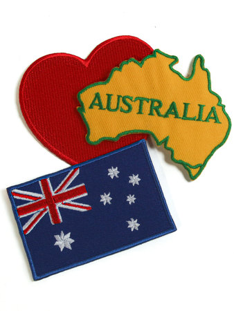 Embroidery of Australia map, heart, and flag placed at center on white background. Textile-based...