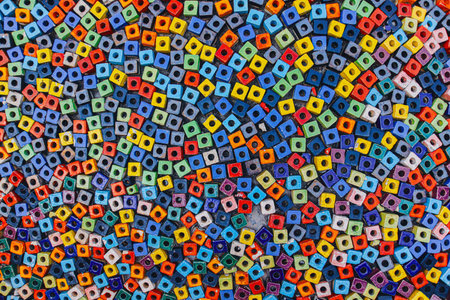 Artistic mosaic background of multicolor hollow square beads, zoomed out texture symbolizing creative diversity and handmade craft design.の写真素材