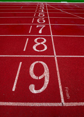 Close up finish line on red athletics track, lanes 1â9, symbolizing sports, victory, motivation and success.の写真素材