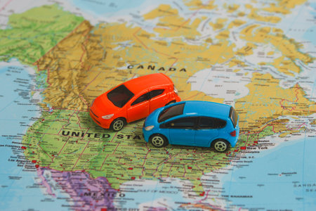 Red and blue toy cars on USA and Canada map, perfect for concepts of travel planning, car rental, road trips and North America adventure.の写真素材