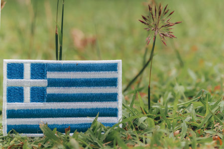 Handcrafted flag from colorful threads on grass with tiny flowers. Eco friendly, earth day, natural calmness. Space on right for text or design.の写真素材