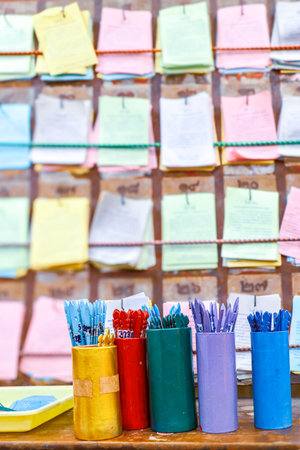 Pastel colorful canisters with various stationery items, set against a background of colorful notes...