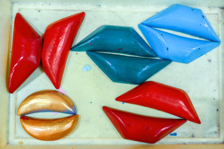 Overhead view of colorful handmade wooden fortune sticks in pastel red, blue, green, and gold, used...