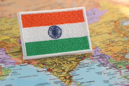 The embroidered flag of India lies on the map at Indiaâs position. Crafted from fabric and thread, it symbolizes eco-tourism, cultural pride, and slow travel.の写真素材