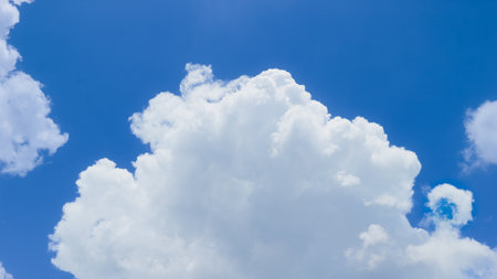Blue sky Zoomed view of a cotton-like cloud under soft sunlight on a bright blue tropical sky. Calm and airy background for nature or weather themes.の写真素材