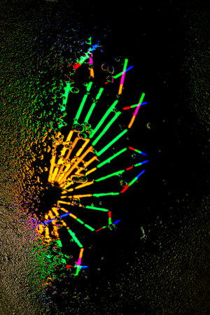 Abstract vertical image of colorful lights reflecting on a wet surface. Vivid red, blue, and green tones create a dreamy, festive night background.の写真素材