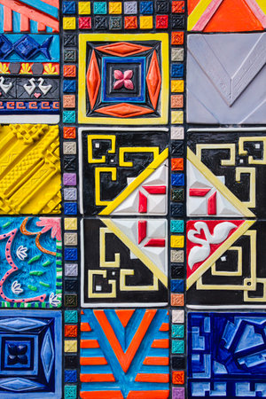 Handcrafted colorful ceramic tiles forming a vibrant geometric mosaic. Abstract background with artistic texture and detail.の写真素材