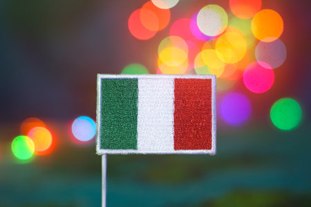 Italian flag in front of a multicolor bokeh background. Concept of holiday joy, national pride, eco travel, and celebration. Ideal for seasonal or branding visuals.の写真素材