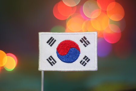 Colorful bokeh lights behind South Korean flag, symbolizing pride, independence, cultural identity, and modern celebration of unity and joyful travel.の写真素材