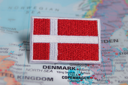 Hand-stitched eco Denmark flag on the map of Scandinavia. Ideal for travel content about nature,...
