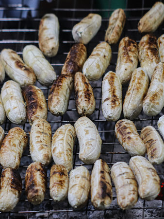 Thai bananas grilled over hot charcoal, a rustic and sweet street snack from bustling night markets.の写真素材