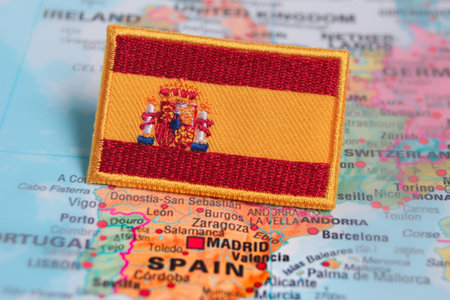 Detailed embroidered Spanish flag on a world map marking Spain, celebrating patriotism, heritage,...