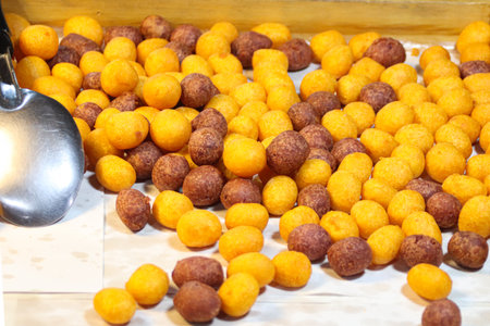 Crispy Thai fried yam balls, golden yellow and purple in color, a sweet and crunchy dessert made...