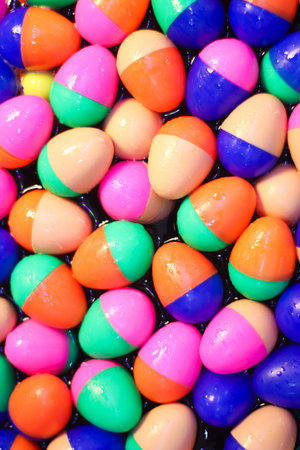 Abstract background with glossy multicolor plastic eggs floating on water. Bright, playful, and vibrant, perfect for summer-themed creative projects.の写真素材