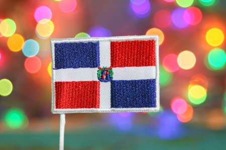 Dominican Republic flag in front of colorful bokeh lights, festive background like fireworks, perfect for national holiday, New Year, and celebration themes.の写真素材