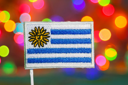 Uruguay embroidered flag with rainbow bokeh circles glowing like fireworks, representing national pride, independence day, and joyful New Year holiday mood.の写真素材