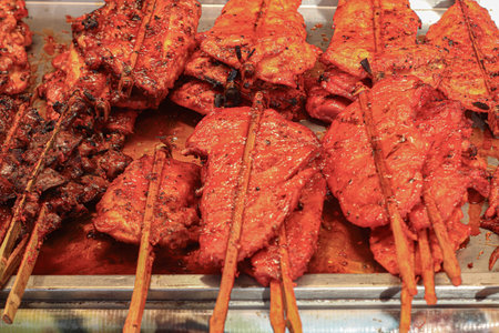 Grilled chicken skewers with red Thai sauce, juicy and charred, showcasing authentic street food flavors and culinary tourism appeal.の写真素材