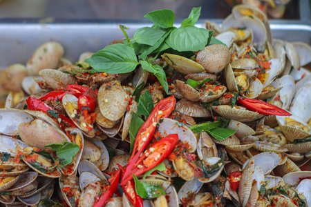 Thai stir-fried clams with basil and chili, iconic street food with bold spices and herbs, representing authentic local seafood cuisine.の写真素材