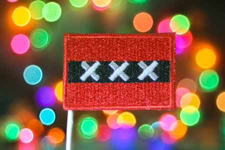 Amsterdam city flag embroidery with colorful bokeh light circles, symbol of festive New Year, holiday celebration, and European national pride.の写真素材