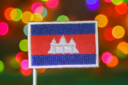 Cambodia embroidered flag with rainbow bokeh fireworks background, symbolizing cultural pride, New Year, holiday, and national day celebrations.の写真素材