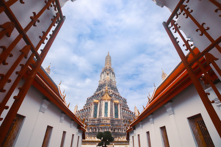 Ancient red gate at Wat Arun in Bangkok, Thailand, leading to the iconic Phra Prang with ornate...