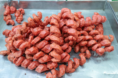 Close-up of crispy Thai pork sausages (spiral cut) on a metal tray. A vibrant and delicious Thai street food and fast food appetizer, highly popular in Asia.の写真素材