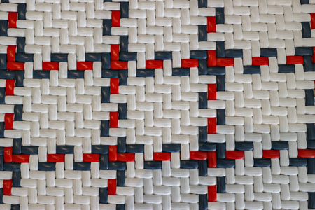 Abstract geometric texture Close-up of tightly woven plastic straps in a white, red, and blue...