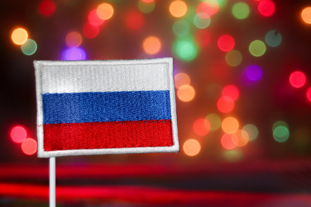 Russia flag (white, blue, red) against a vibrant rainbow bokeh background. Represents international relations, news, national day, culture, and festive celebration concepts.の写真素材