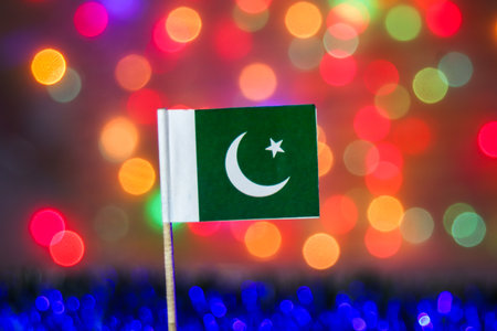 Pakistan flag with crescent and star against a festive, rainbow bokeh background. Represents South Asian independence, national day, and cultural celebration concepts.の写真素材