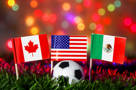 Soccer football with flags of Canada, USA, and Mexico on grass against festive bokeh. Represents North American cooperation, global competition, and major sports event celebration.の写真素材