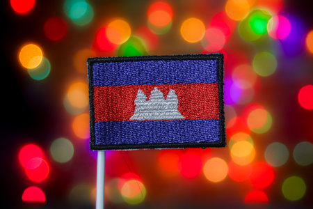 Cambodia flag featuring Angkor Wat against a festive bokeh background. Represents Asian tourism, national sovereignty, Khmer culture, and Independence Day celebration.の写真素材