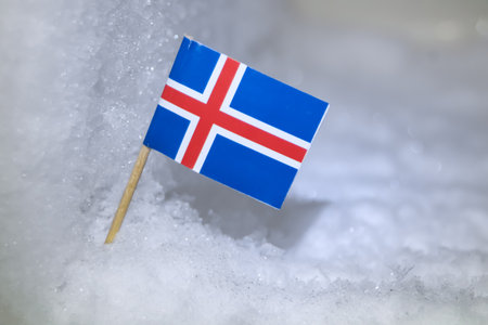 Close-up of the Icelandic flag in a frozen, glacial environment. Symbolizes the country's unique...