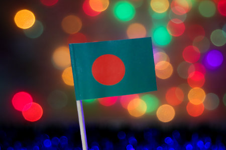 Bangladesh flag with red circle on green and vivid bokeh background. Perfect for national day, travel, and Asian cultural celebration themes.の写真素材