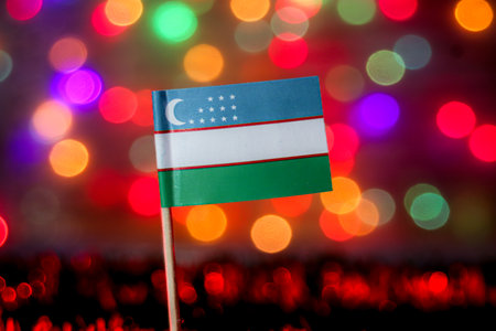 Uzbekistan flag with soft bokeh lights representing celebration, Silk Road culture, and independence. Ideal for travel, education, and cultural visuals.の写真素材