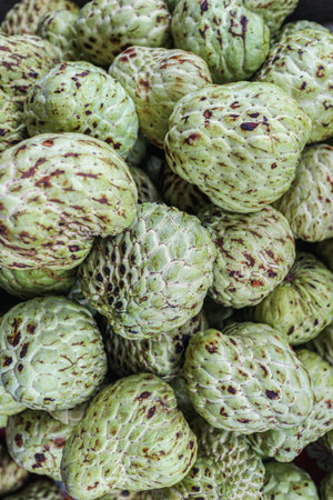 Top view of organic custard apples forming a liminal abstract texture, ideal for themes of tropical...