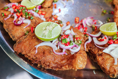 Crispy fried fermented fish with chili, red onion, and lime, showcasing the spicy and aromatic character of authentic Isaan Thai cuisine and exotic comfort flavors.の写真素材