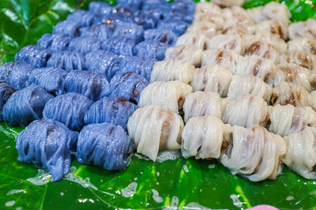 Thai steamed rice skin dumplings Pak Mor with butterfly pea blue color. Drizzled with coconut cream....