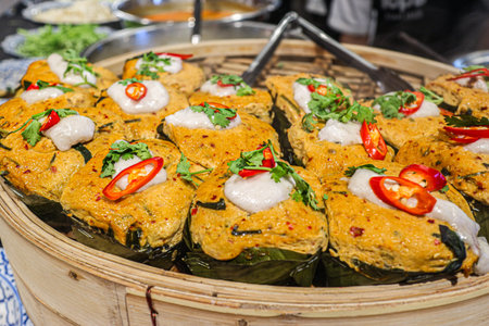 Traditional Ho Mok Thai steamed curry fish mousse in banana leaf cups reflecting authentic herbal...
