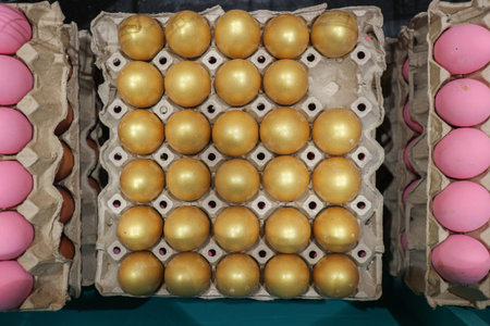 Golden egg among pink eggs in a carton. Conceptual flat lay.
