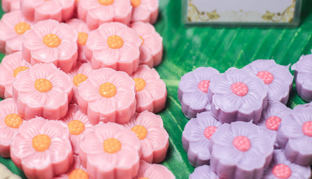 Traditional Thai alua jelly candy shaped as pastel pink and purple flowers, highlighting romantic...