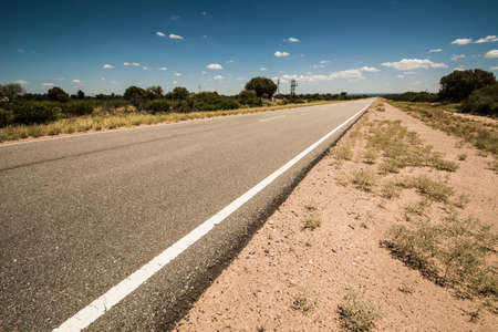 Desert road from below with blue skyの写真素材
