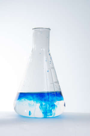 Graduated Erlenmeyer glass flask with blue liquidの写真素材