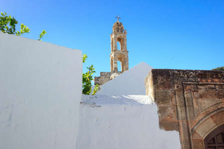 The bell tower of the Church of Panagia on the background of blue sky, Lindos, Greece.の写真素材