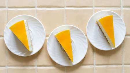 Top view three cheesecakes with orange frosting, background.の写真素材