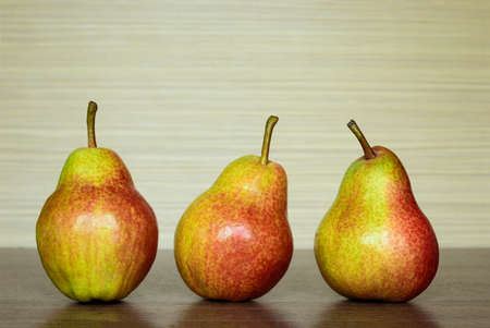 Three red and yellow pears on the kitchen table.の写真素材