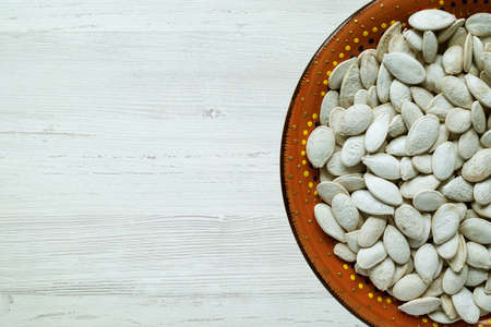 Top view dried pumpkin seeds on a ceramic plate.の写真素材
