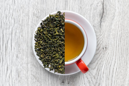 Tea in a cup and dry green tea leaves on a white plate.
