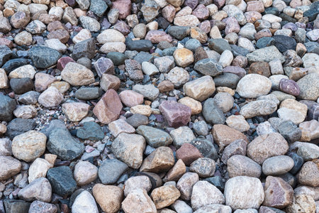 Surface covered with stones and cobblestones, background.の写真素材