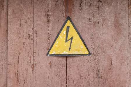 Warning sign for electrical voltage on an old substation door.の写真素材